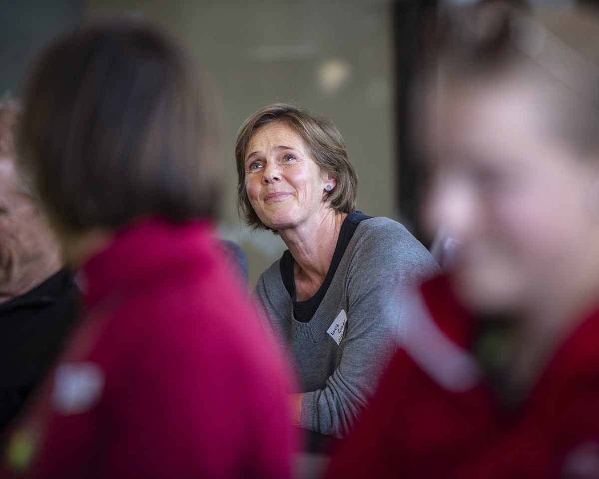 A businesswoman in the audience listens to a presenter