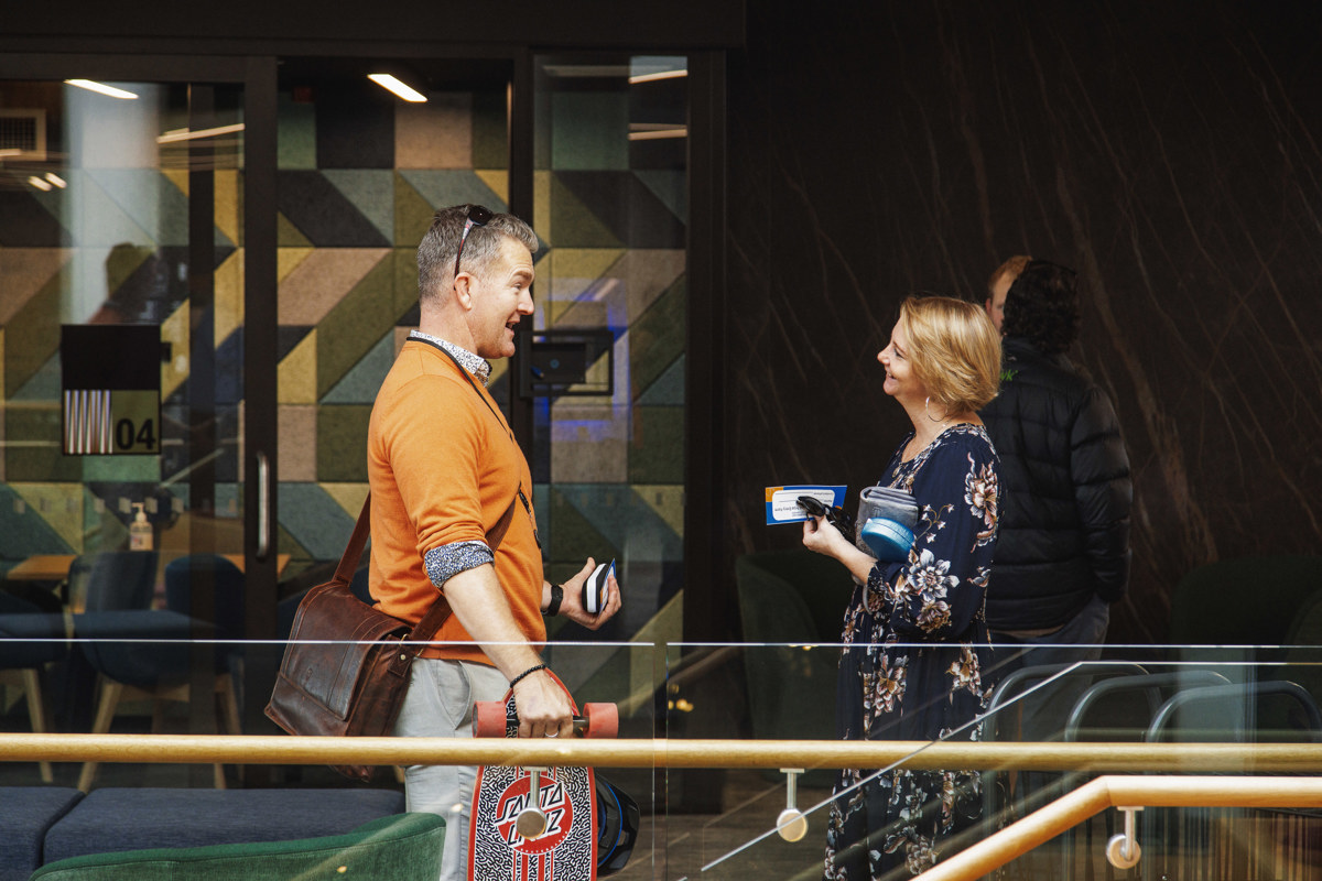 Two businesspeople chat outside the meeting rooms at the Marlborough Library