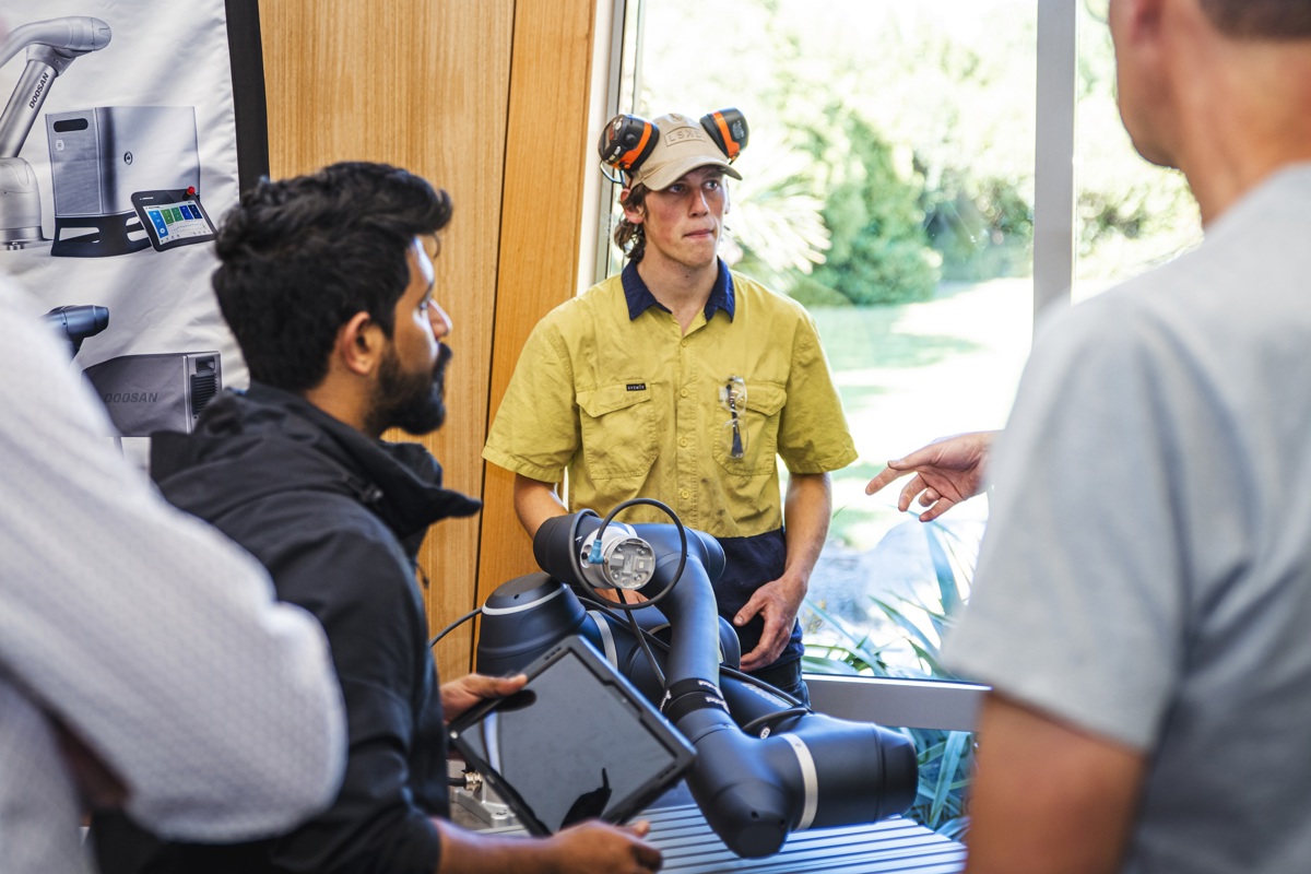 A young man demonstrates a new machine to onlookers